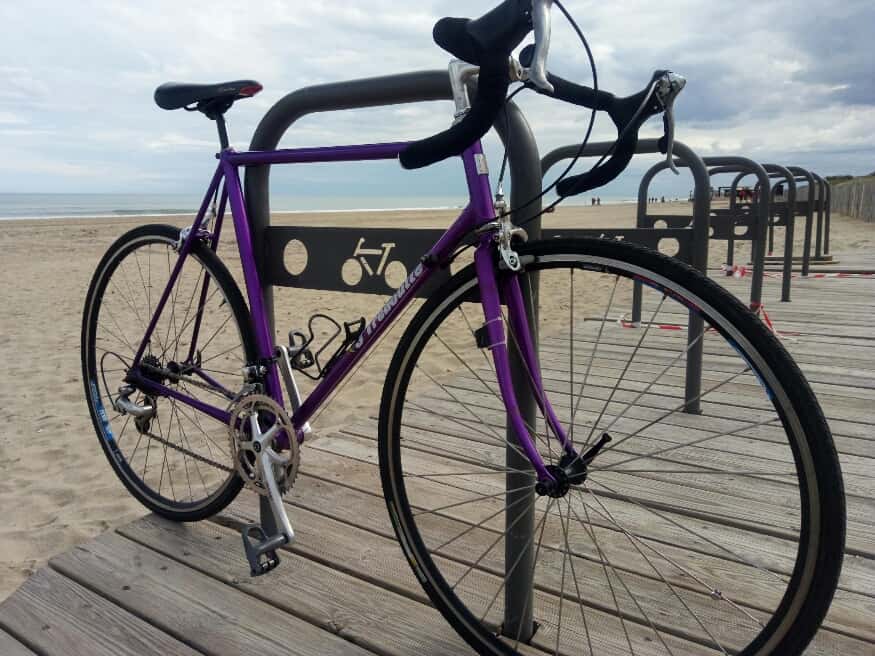 Image of purple vintage bike on beach